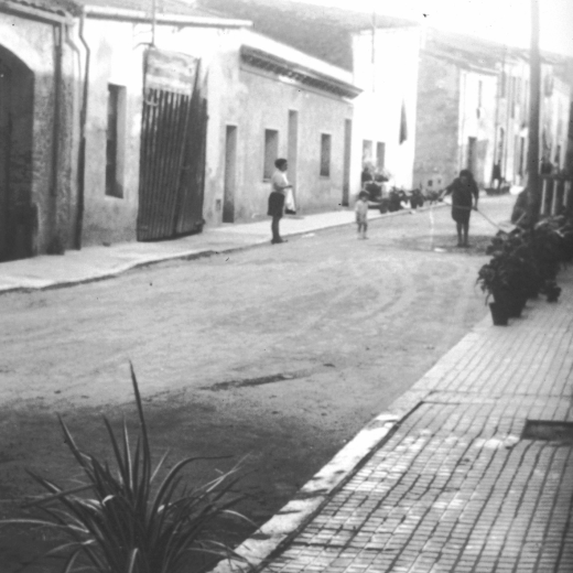 Detall del carrer dels Dolors amb algunes cases que més tard foren enderrocades i reconstruïdes de nou.

Aquesta portalada gran amb una porta força destartalada era el conegut garatge d'en Peret dels Autos, on durant molts anys s'hi tancaven els autocars de línia de Maçanet des de la primera època dels anys 20 fins els anys 70 en què arribà una nova època i nous mitjans de transport públic.