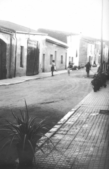 Detall del carrer dels Dolors amb algunes cases que més tard foren enderrocades i reconstruïdes de nou.

Aquesta portalada gran amb una porta força destartalada era el conegut garatge d'en Peret dels Autos, on durant molts anys s'hi tancaven els autocars de línia de Maçanet des de la primera època dels anys 20 fins els anys 70 en què arribà una nova època i nous mitjans de transport públic.