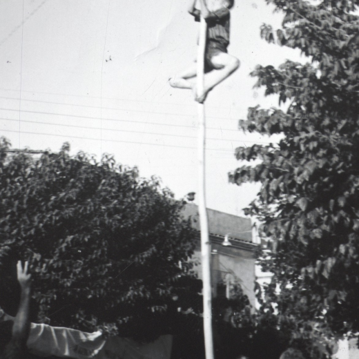 Festa Major del 1960. Jocs de cucanya a la plaça de l'Església. A peu del pal s'hi pot veure a Josep Roura, un dels organitzadors dels jocs.