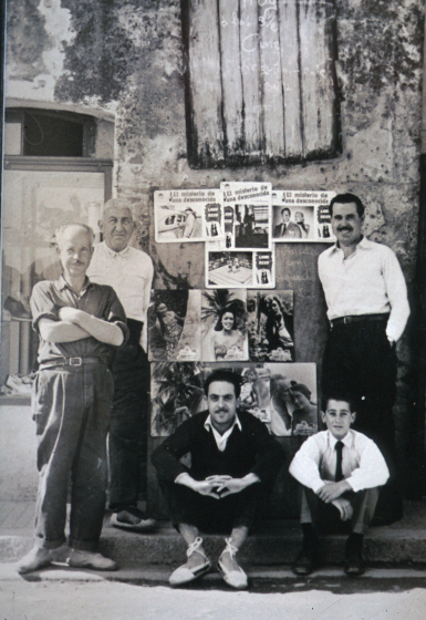 Pissarra anunciadora dels actes festius de la Societat Recreativa que es col·locava a la plaça de l'Església a la paret delq ue ara és el Casal del Cavaller.

Drets: Miquel Masjoan (l'avi Jordi), Jordi Iglesias (el sabater), Francesch Bosch (Xicu Ros) i asseguts l'Agustí Xarbau i Joan Selva Bataller.