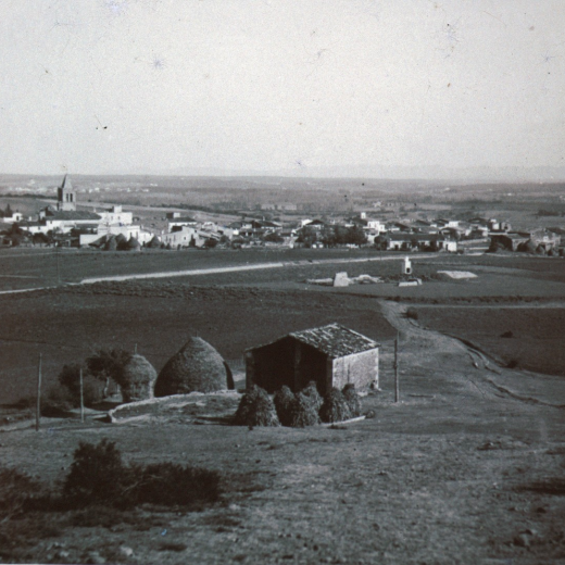 Vista panoràmica de la vila de Maçanet des del Turó d'en Roura amb el porxo i els pallers de Can Roura.
