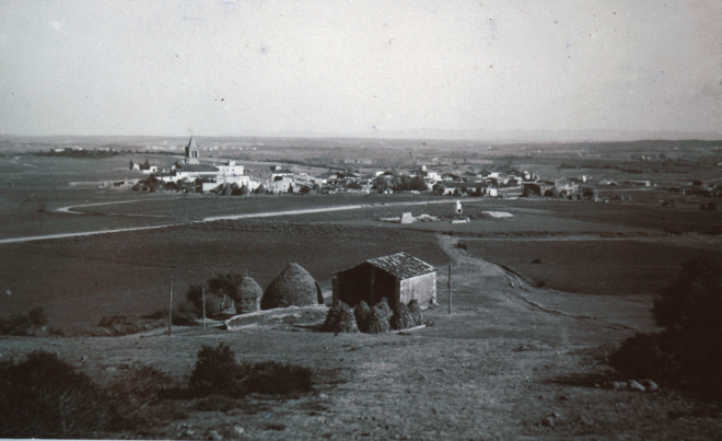 Vista panoràmica de la vila de Maçanet des del Turó d'en Roura amb el porxo i els pallers de Can Roura.